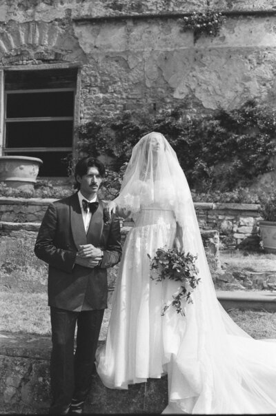 A wedding couple hold hands and walking together as they laugh 
