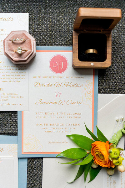 white invitation suite and wedding rings