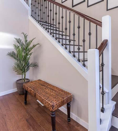 the entryway to an Atlanta Georgia home, showing a staircase, a bench, and a plant