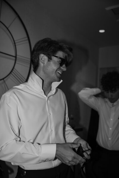 Evan having fun with his groomsmen while getting ready for his wedding, in black and white