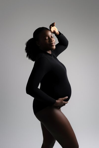 Studio portrait featuring a long-sleeve black bodysuit for maternity