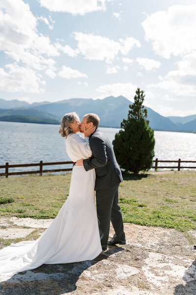 couple kisses during their wedding on Lake Dillon, Colorado 