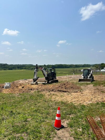 Skid steers prepping soil for septic install