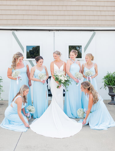 Laughter-filled candid shot of bride and bridesmaids getting ready before the ceremony.