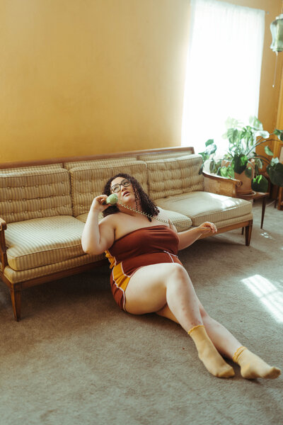 Woman sitting in a retro living room holding a corded phone
