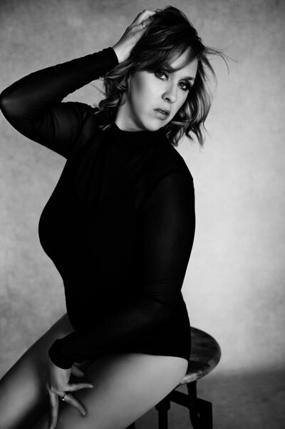 black and white image close up portrait of woman with hand by her face