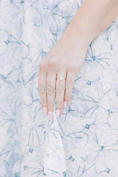 Atlanta Engagement Photographer | Bride-to-be showing off engagement ring against floral dress fabric