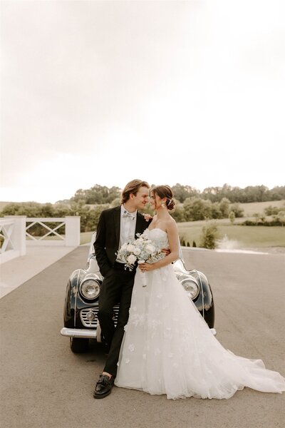 bride and groom at their nashville wedding, posing near a vintage car