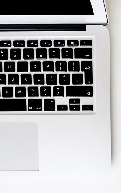 image of a keyboard with black keys and silver laptop