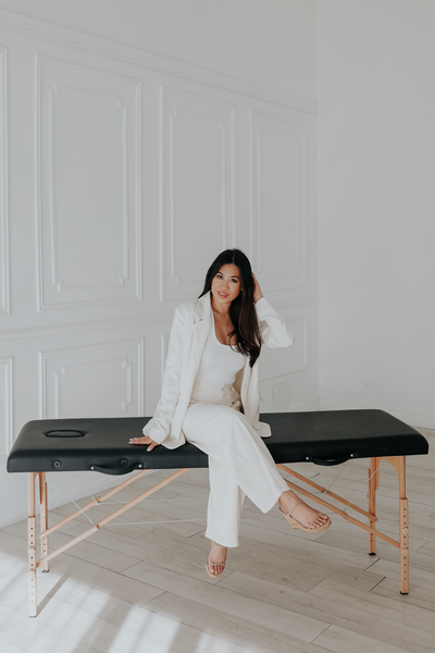 woman in white suit sitting on massage bed