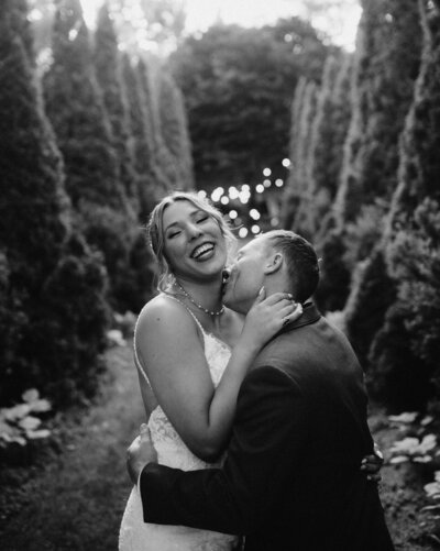 bride and groom snuggling under the twinkly lights and laughing at cranberry creek gardens wedding venue