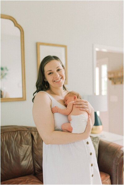 Mother embraces her newborn baby in her living room