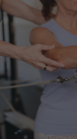 close up image of a hand guiding a woman's arm 