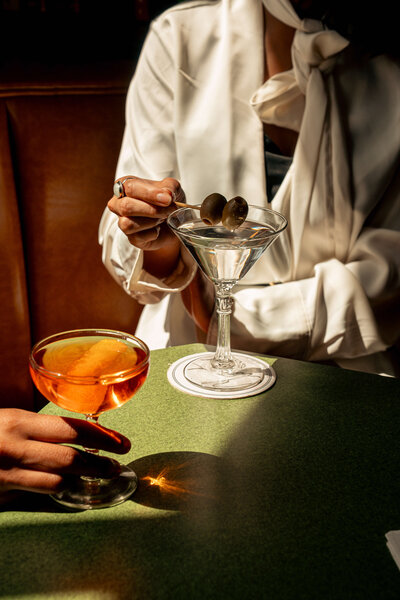 Character Study cocktails in Asheville, North Carolina featuring a model holding olives over her martini at golden hour.