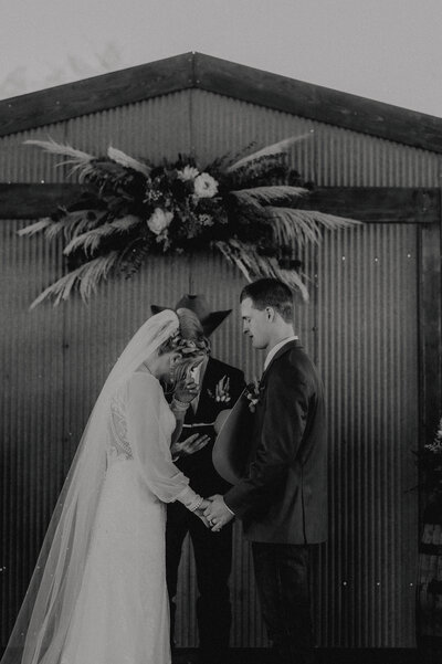 couple praying as bride wipes a tear away during their ranch wedding