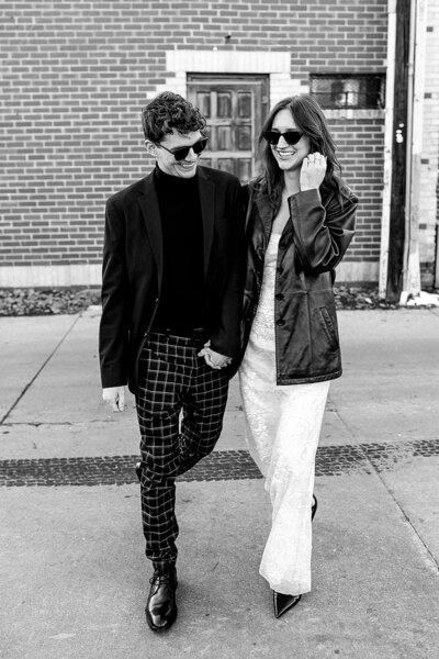 couple holding hands and walking and smiling