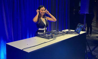 Female DJ at corporate Samsung event against a illuminated electric blue background
