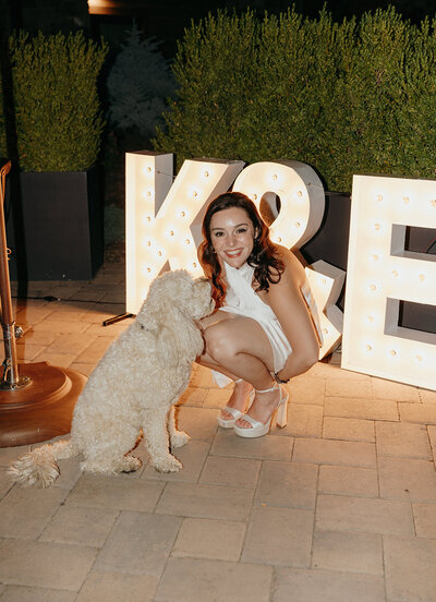 The bride shares a joyful moment with her pup during the welcome party—celebrating love, laughter, and a four-legged best friend by her side.