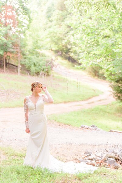 A bride stands on a winding pathway behind the bamboo forest at Camelot Meadows.