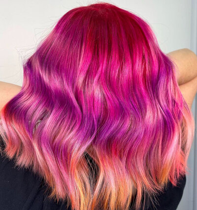 Image of client with bright, vivid pink hair that has orange lowlights.
