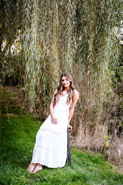 Girl sitting by willow tree