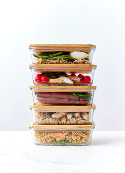 meal prepped lunches stacked on top of each other in glass containers