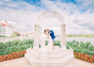 Couple kissing under the white arbor beside the lake at Disney World Fairytale Wedding Pavilion