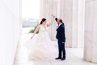 A bride and groom share a dance behind the pillars of the Lincoln Memorial during their wedding in Washington DC