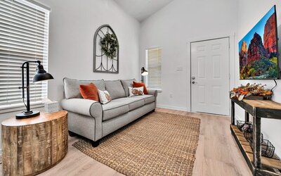 Living area with comfortable couch and neutral tones in this 2-bedroom, 1 bathroom vacation rental home located 4 minutes from delicious Magnolia Table and 5 minutes from the beautiful Baylor campus in Waco, TX