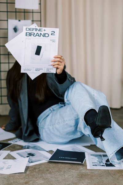 Woman holding branding information to her face in a website design studio