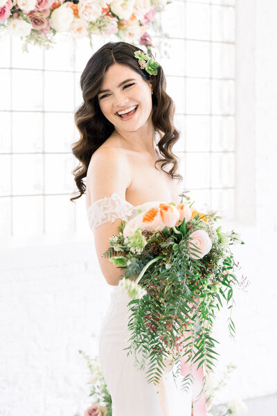 bride laughing and having fun with a bouquet in her arms