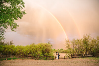 Bride and groom laughing during colorful sunset