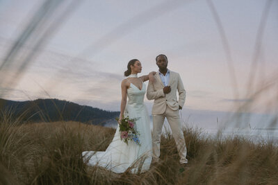 Intimate moment between a couple standing on the coast in Tofino after their Vancouver Island elopement
