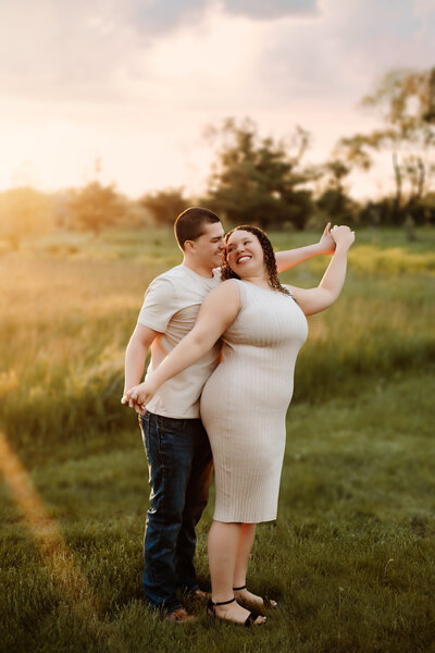 This couple stands close together while mimicking an airplane during their summer mini session.