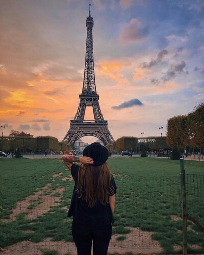 girl with hat posing in front of Eiffel Tower