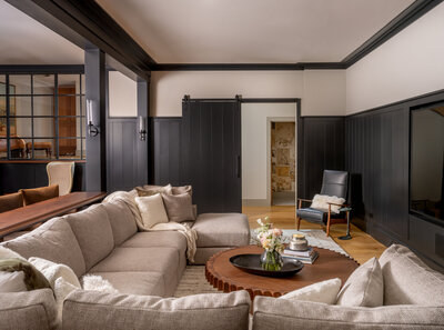 soft and light living room with blue gray barn doors and tan furniture
