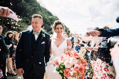 A newly married couple walking through confetti taken by Cornwall Wedding Photographer and Devon Wedding Photographer Liberty Pearl