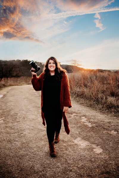 Family, Maternity & Newborn Photographer,  Jessica Rockowitz walks down a country road with her camera in hand at golden hour