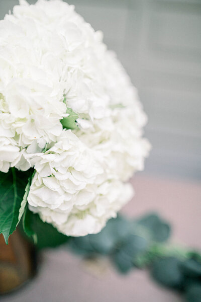 This image by Tiffany Longeway beautifully showcases the pristine elegance of white wedding flowers, symbolizing purity and grace, and adding a touch of refined sophistication to the wedding decor.