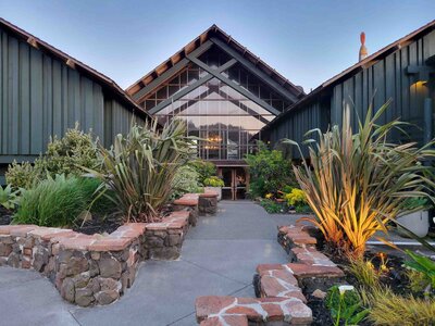 Rustic lodge entrance framed by lush greenery in Northern California at dusk ©Stephanie Dosch | theViatrix Personalized Travel Planning