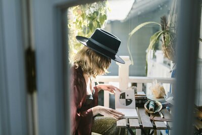 Woman in black hat reading natal charts