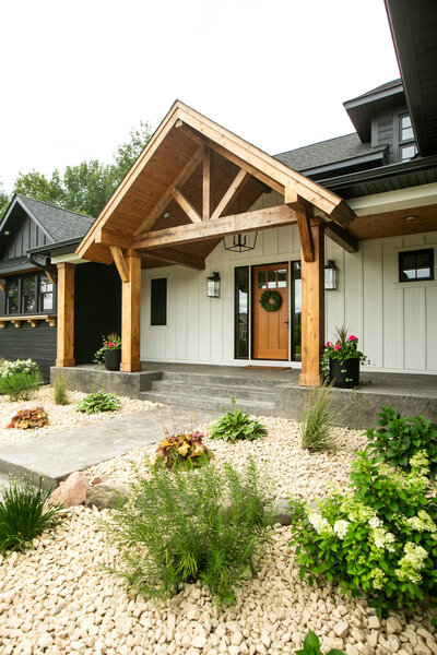 Custom Minnesota Home in Otsego built by Cornerstone Custom Builds with white and black siding and wood pillars.