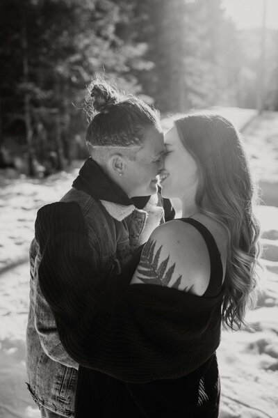 lgbt couple kissing in snowy forest