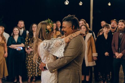 Bride and groom laughing during their first dance under eddison lights at Venue On The Rocks