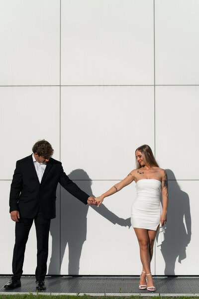 Engaged couple walking together in city streets — contemporary urban wedding photography by The Proper Collective in the Midwest.