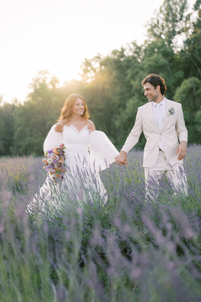 Bride and groom running through lavender fields