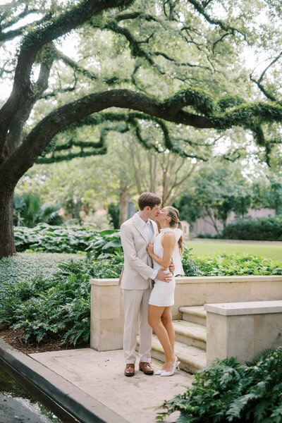 Engaged couple walk hand in hand through a park at their engagement photography session