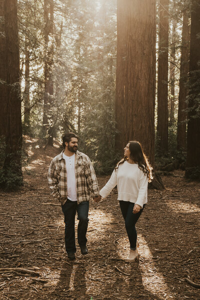 Newly engaged couple walks in the Oakland Redwood forest