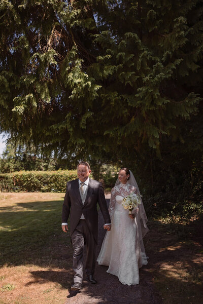 Wedding photographer captures couple taking a stroll hand in hand at their french chateau wedding.