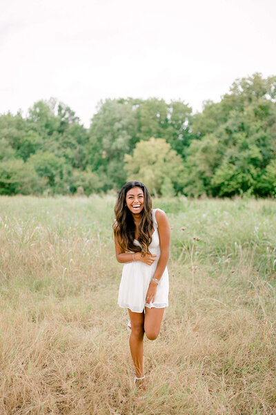 Girl laughing in a field located in Richmond Virginia.